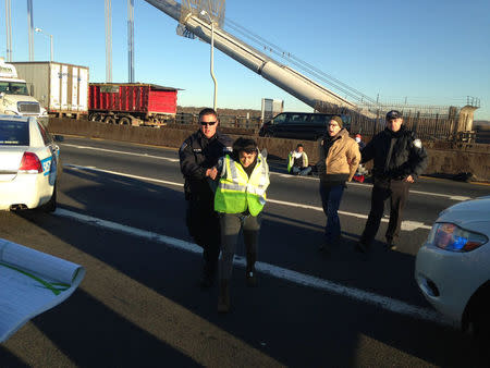 Police officers detain protesters who had been holding a pro-immigrant sign while blocking several lanes of the upper level of the George Washington Bridge in New York, New York, U.S. October 26, 2016. @sosui140/Handout via REUTERS