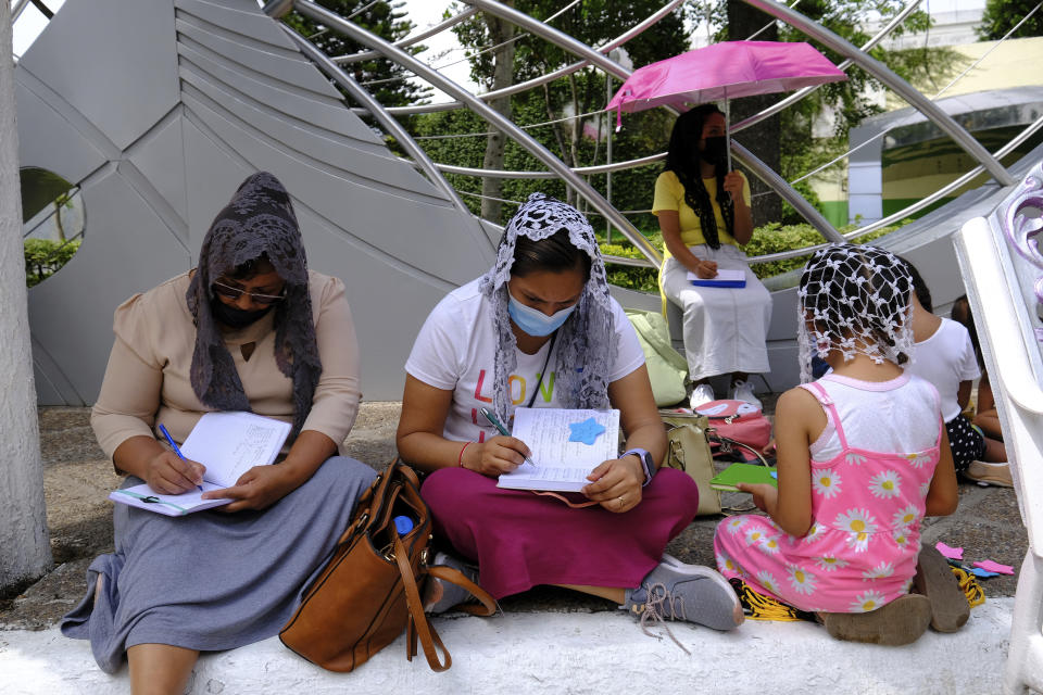 Faithful sit in contemplation on the grounds of the La Luz del Mundo or the Light of the World flagship temple in Guadalajara, Mexico, Saturday, Aug. 13, 2022. Congregation members in the neighborhood call each other “brother” and “sister” and take pride in helping one another. The church’s media relations office claims there is no crime in the area. (AP Photo/Refugio Ruiz)