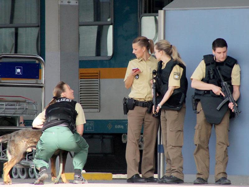 Schwer bewaffnete Polizisten durchsuchen den Bahnhof von Kempten. Foto: Thomas Pöppel