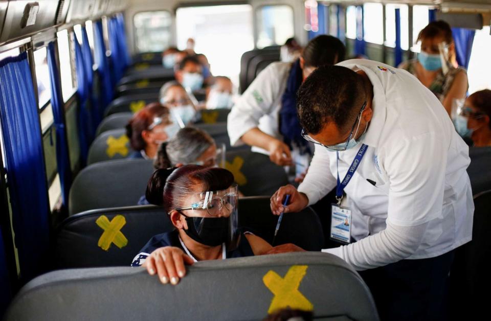 PHOTO: Onboard a bus, assembly factory workers in Ciudad Juarez, Mexico receive a dose of the Pfizer-BioNTech COVID-19 vaccine, May 24, 2021. (Jose Luis Gonzalez/Reuters)