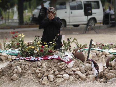 A woman mourns at the graves for miners who died in a fire at a coal mine, at a cemetery in Soma, a district in Turkey's western province of Manisa May 20, 2014. REUTERS/ Osman Orsal