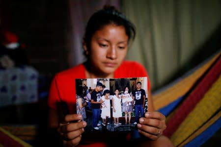 Norme Mendez, wife of Salvadoran migrant Marvin Antonio Gonzalez, who recently died in a border detention center in New Mexico, shows pictures of Marvin at her home in Verapaz