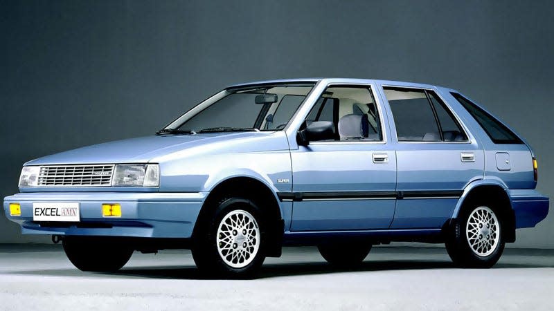 A photo of a pale blue Hyundai Excel car in a studio. 