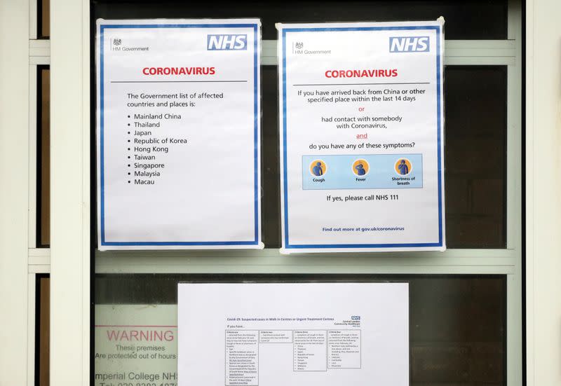 Signs relating to Coronavirus are seen on the front entrance to Parson's Green Medical Centre in London