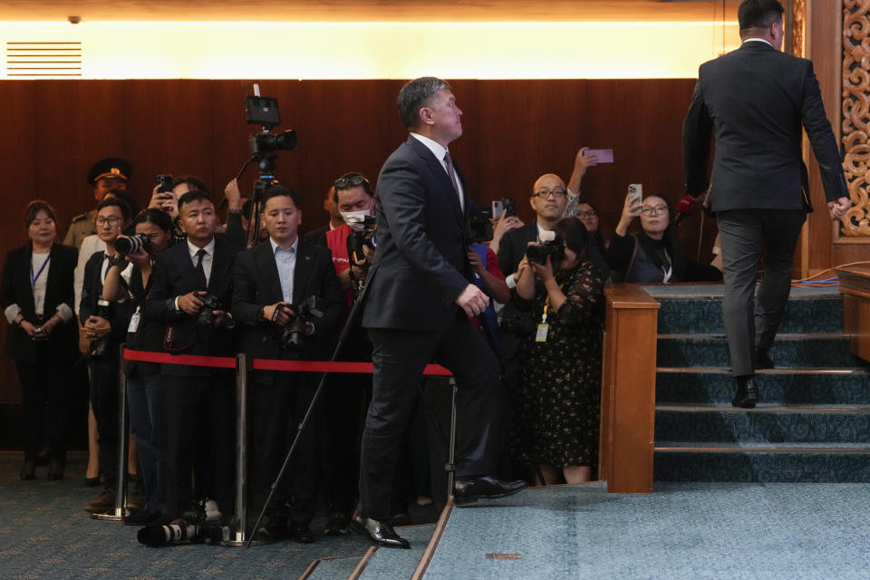 Journalists watch as newly elected lawmakers walk on stage to receive their parliamentary membership cards at the Mongolian Government Palace in Ulaanbaatar, Mongolia, Monday, July 1, 2024. (AP Photo/Ng Han Guan)