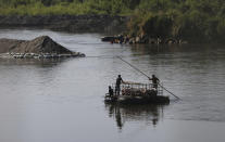 Personas transportan cerdo en el río Suchiate en la frontera de México a Guatemala, mientras se alejan de Ciudad Hidalgo, México, el viernes 24 de enero de 2020. (AP Foto/Marco Ugarte)