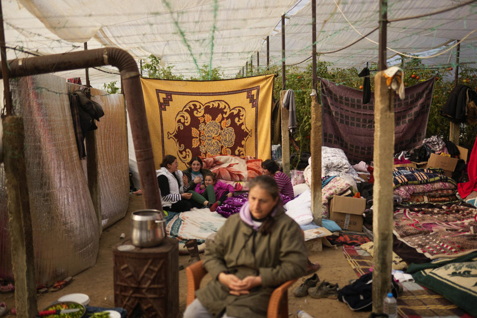 FILE - Young girls sit and talk inside a greenhouse where they shelter with relatives following the earthquake in Samandag, southern Turkey, on Feb. 16, 2023. Hundreds of thousands of people are seeking shelter after the Feb. 6 earthquake in southern Turkey left homes unlivable. Many survivors have been unable to find tents or containers dispatched to the region by the government and aid agencies, Instead they have sought refuge in any structure that can protect them from the winter conditions, including greenhouses, rail carriages and factories. (AP Photo/Francisco Seco)