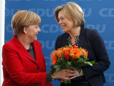 German Chancellor and leader of the Christian Democratic Union (CDU) Angela Merkel, presents flowers to Julia Kloeckner (R) top candidate in the Rheinland-Palatinate state election, at a party board meeting in Berlin, Germany March 14, 2016. REUTERS/Fabrizio Bensch