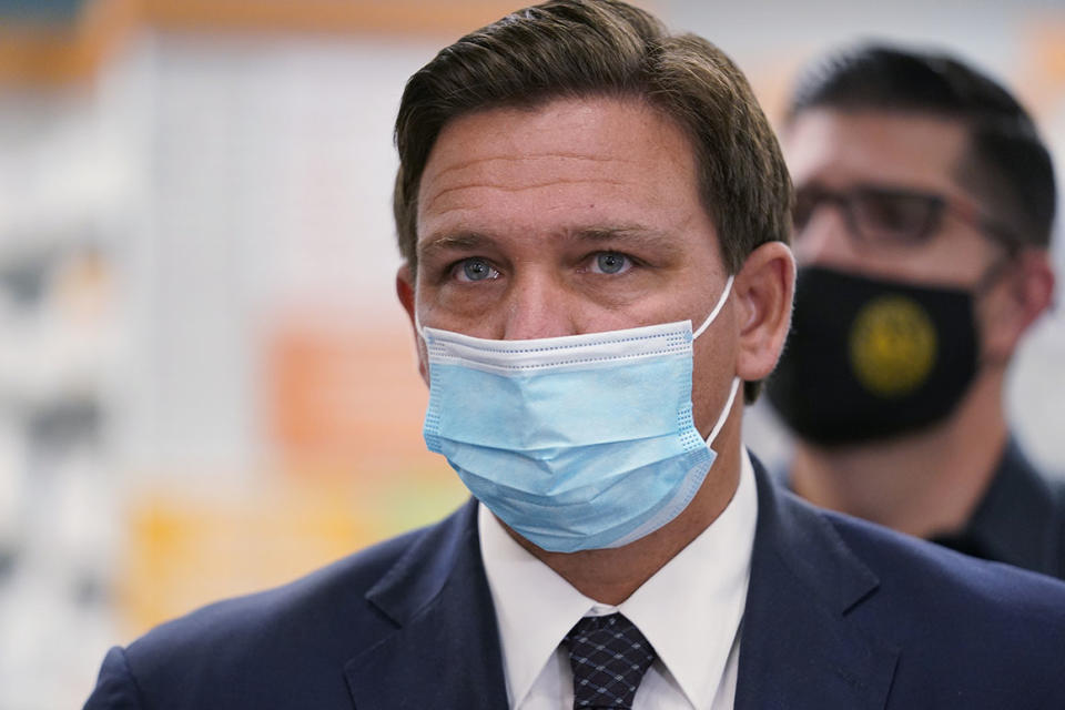 Wearing a mask to prevent the spread of COVID-19, Florida Gov. Ron DeSantis looks on during a news conference, Tuesday, Feb. 23, 2021, at a Navarro Discount Pharmacy in Hialeah, Fla. DeSantis announced that seniors will soon be able to receive COVID-19 vaccinations at Navarro Discount Pharmacies and CVS y mas pharmacies in Miami-Dade County. (AP Photo/Wilfredo Lee)