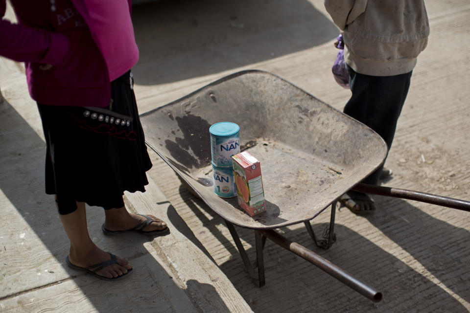 In this Feb. 11, 2014 photo, a woman stands next to her wheelbarrow as she shops for supplies at a state-run store in Cochoapa El Grande, Mexico. Seven million Mexicans the government says are suffering from a combination of extreme poverty and malnourishment even as the country suffers from among the world’s highest rates of obesity. (AP Photo/Dario Lopez-Mills)