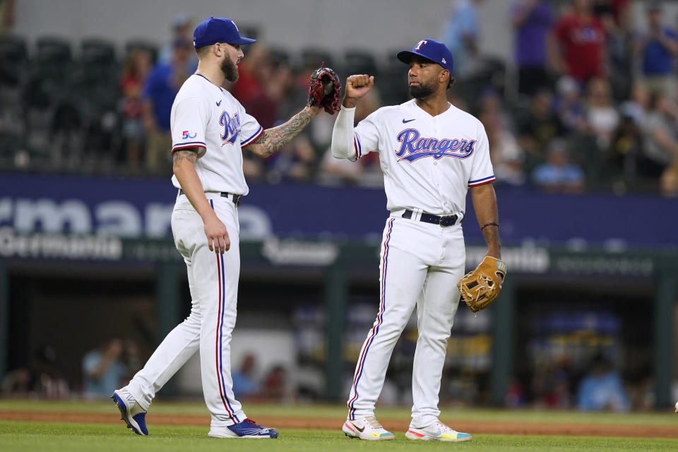 Texas Rangers closer Joe Barlow, left, is congratulated by third baseman Ezequiel Duran after the final out of the team's baseball game against the Seattle Mariners in Arlington, Texas, Saturday, June 4, 2022. The Rangers won 3-2. (AP Photo/LM Otero)