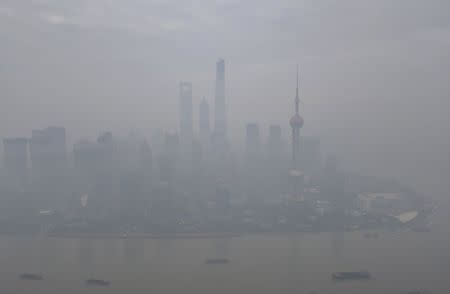 Boats pass along the Huangpu River next to the financial area of the Pudong New District amid heavy smog in Shanghai, China, November 30, 2015. Heavy smog and thick fog engulfed many parts of northern and eastern China on Monday, local media reported. REUTERS/Stringer