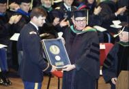 U.S. Army Medical Corps retired Lt. Colonel John Hagmann (L) is seen being presented the William P. Clements, Jr. Outstanding Uniformed Educator Award by Dr. Sam Nixon (R) during the U.S. Military's Uniformed Services University of the Health Sciences 1989 Commencement Exercises in this USUHS handout file photo taken in Washington May 20, 1989. REUTERS/Uniformed Services University of the Health Sciences Handout via Reuters