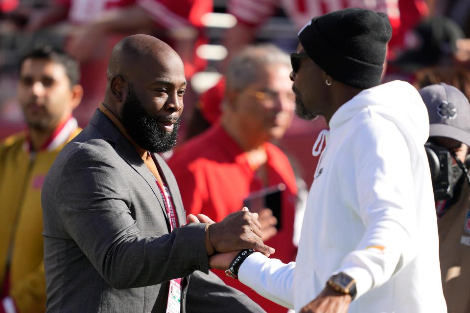 San Francisco 49ers director of personnel Ran Carthon, left, greets former wide receiver Jerry Rice before an NFL football game between the 49ers and the Minnesota Vikings in Santa Clara, Calif., Sunday, Nov. 28, 2021. (AP Photo/Tony Avelar)