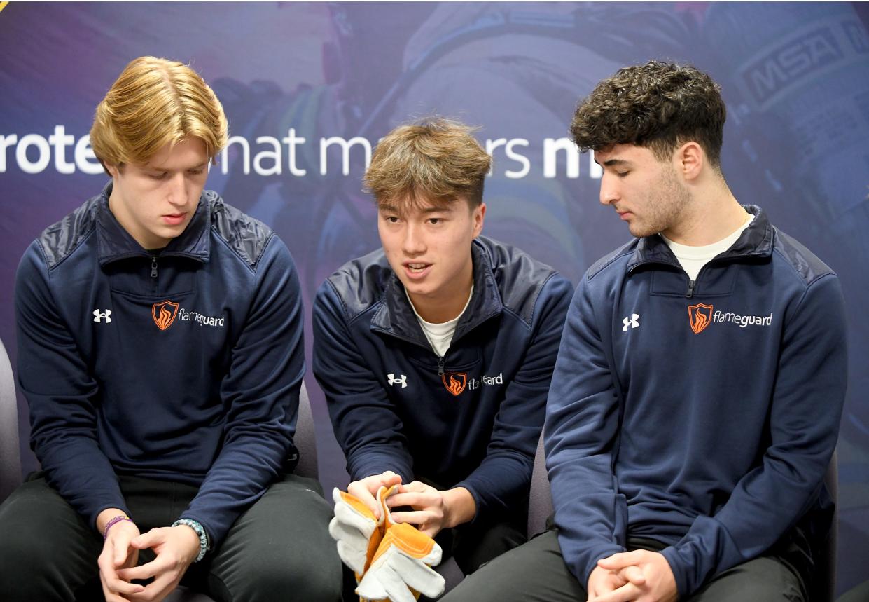 Jackson High School students Zachary Ferguson, Justin Lackey and Joe Lattarulo, from left, talk about FlameGuard, the business run by their Junior Achievement class.