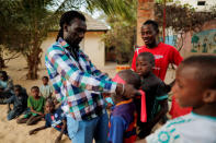 Issa Kouyate (L), 39, the founder of Maison de la Gare, an organisation that helps Koran students, called talibes, reintegrate into society, entertains talibe children at the organisation's courtyard in Saint-Louis, Senegal, February 7, 2019. REUTERS/Zohra Bensemra