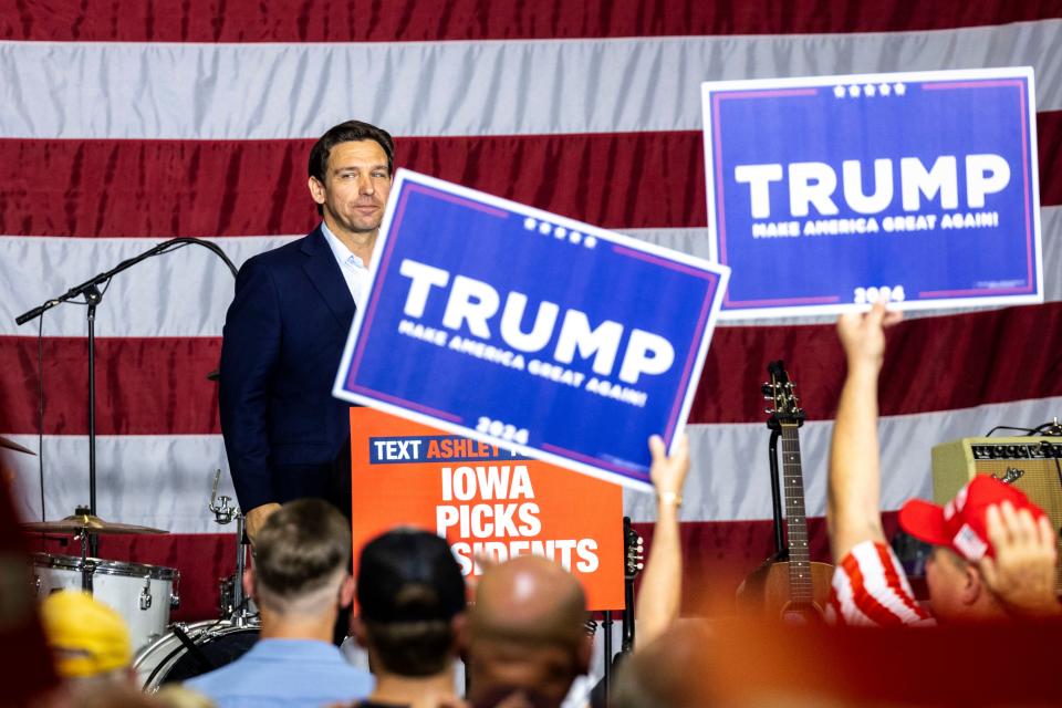 Republican presidential candidate Florida Gov. Ron DeSantis looks into the crowd after speaking as supporters of former President Donald Trump hold up signs during the Ashley's BBQ Bash fundraiser, Sunday, Aug. 6, 2023, at Hawkeye Downs in Cedar Rapids, Iowa.