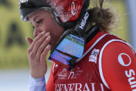 Switzerland's Corinne Suter gets to the finish area after crashing during an alpine ski, women's World Cup downhill race, in Cortina d'Ampezzo, Italy, Friday, Jan. 20, 2023. (AP Photo/Alessandro Trovati)