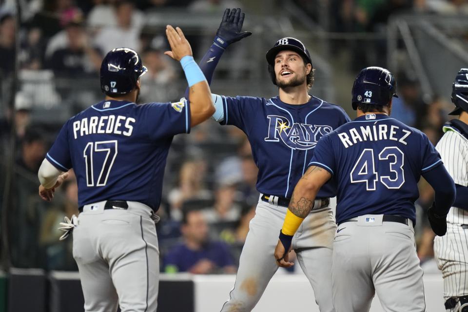 Tampa Bay Rays' Josh Lowe, center, celebrates with Isaac Paredes (17) and Harold Ramirez (43) after they scored on a three-run home run by Lowe during the eighth inning of a baseball game against the New York Yankees Friday, May 12, 2023, in New York. (AP Photo/Frank Franklin II)