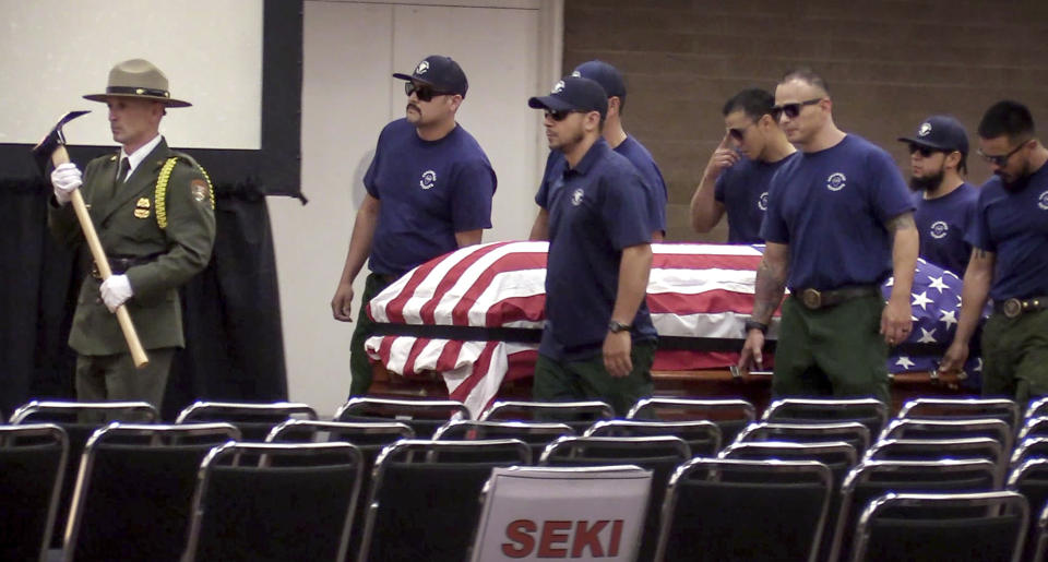 Honor guard and pall bearers carry the coffin of Brian Hughes, a captain with the Arrowhead Interagency Hotshots who was killed by a falling tree while fighting the Ferguson Fire, during a memorial service at Valdez Hall in Fresno, Calif., Saturday, Aug. 4, 2018. (Craig Kohlruss/The Fresno Bee via AP)