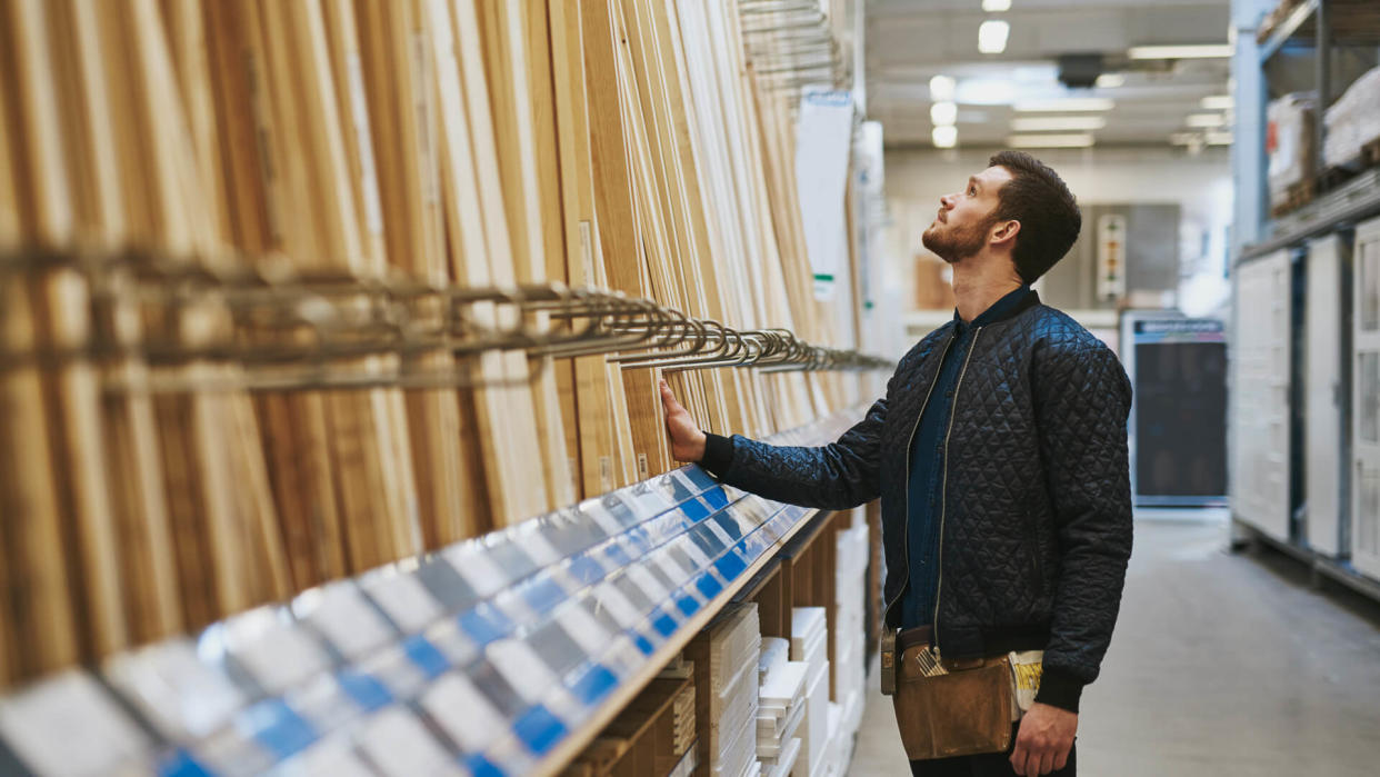 man in hardware shop looking for wood