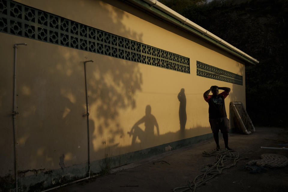 Pescadores hablan mientras se pone el sol en la localidad de Belle Garden, en la isla de Tobago, en Trinidad y Tobago, el 21 de enero de 2022. (AP Foto/Felipe Dana)