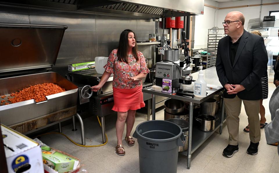 Sandra Montesino, left, greets U.S. Rep. Jim McGovern as he tours the kitchen at Daniel's Table in Framingham, June 28, 2022. A discussion between McGovern and Daniel's Table co-founder David Blais centered around food insecurity solutions.