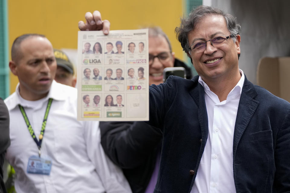 Gustavo Petro, presidential candidate with the Historical Pact coalition, shows his ballot before voting during presidential elections in Bogota, Colombia, Sunday, May 29, 2022. (AP Photo/Fernando Vergara)