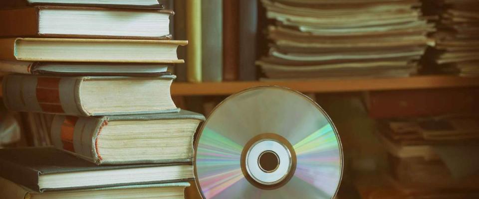 stack of books, library, cd, headphones, wooden table and bookcase