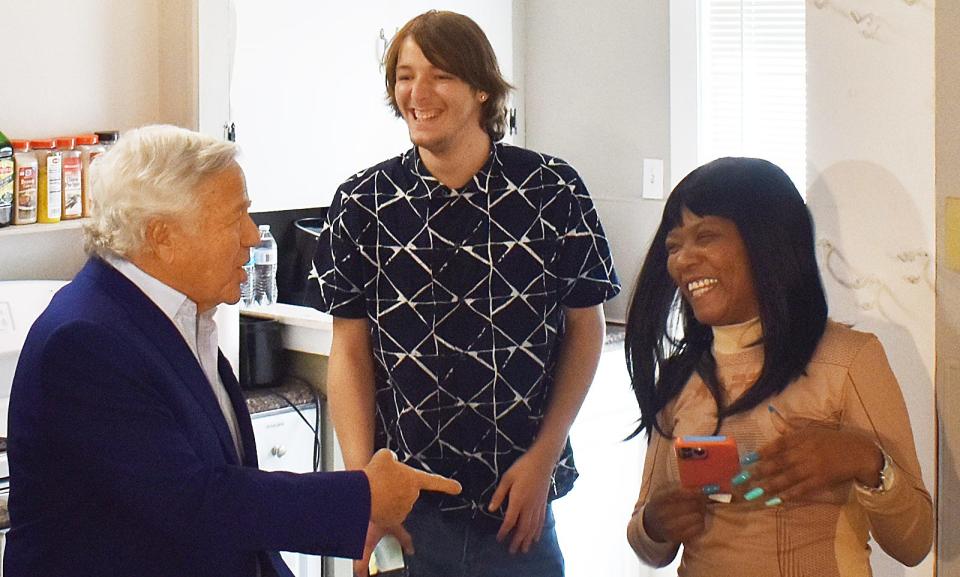 Robert Kraft, Chairman and CEO, New England Patriots, talks with resident Leroy Grifith and Purity Young at the ribbon cutting for the renovated house for young adults in Fall River Wednesday.