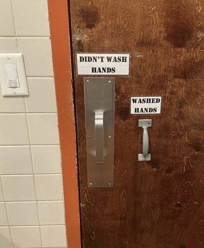 Public restroom door with two handles, the left labeled "Didn't Wash Hands" and the right labeled "Washed Hands"