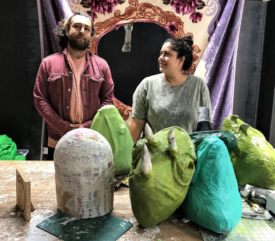 Artists Manuel Urueta and Celina Galicia create papier-mache artworks. Some works in progress by the couple are shown before them. They also create videos.