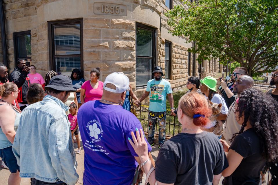 Friends and family gather on Monday, May 29, 2023, to pray and say the names of missing loved ones near the site of an apartment building that partially collapsed in Davenport. The six-story building at 324 Main St. partially collapsed on May 28.