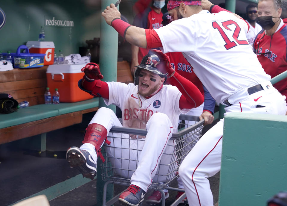 Boston Red Sox's Alex Verdugo is pushed through the dugout in a basket as he celebrates his solo home run with teammate Marwin Gonzalez (12) in the third inning of a baseball game against the Chicago White Sox at Fenway Park, Monday, April 19, 2021, in Boston. (AP Photo/Elise Amendola)