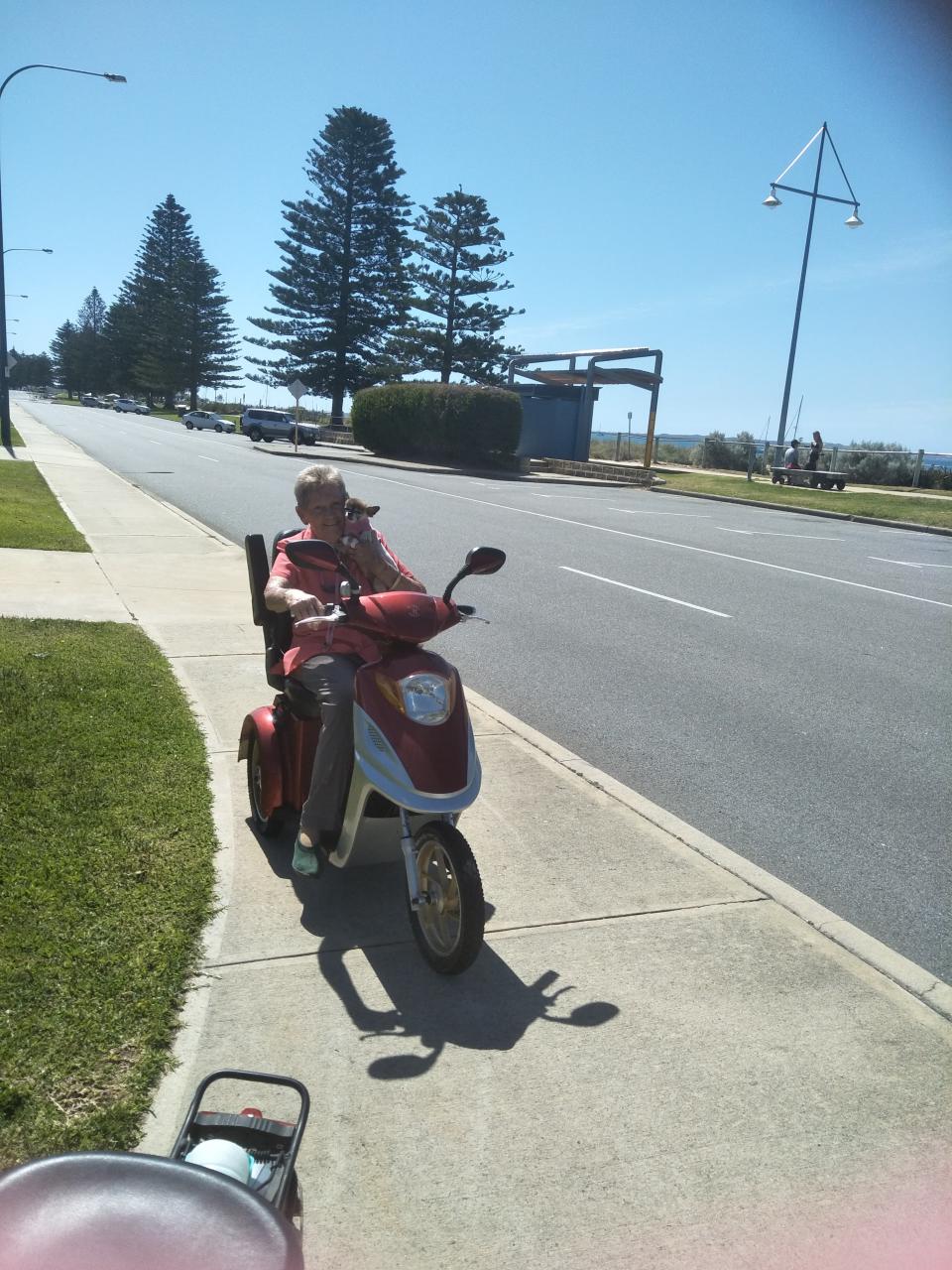 Elderly woman using mobility scooter on footpath as road rules revealed.