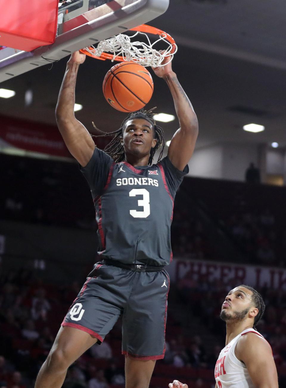 Oklahoma Sooners guard Otega Oweh (3) dunks the ball beside Texas Tech Red Raiders forward Kevin Obanor (0) during a men's college basketball game between the University of Oklahoma Sooners (OU) and Texas Tech at Lloyd Noble Center in Norman, Okla., Tuesday, Feb. 21, 2023. 