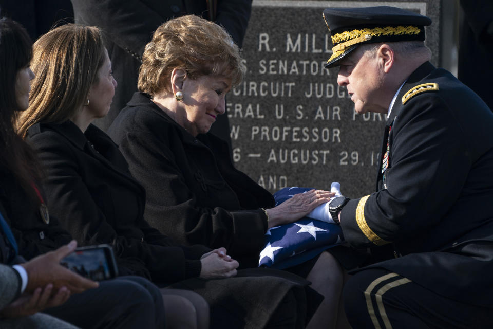 FILE - Chairman of the Joint Chiefs of Staff Gen. Mark Milley presents former Sen. Elizabeth Dole of N.C., a U.S. flag during the burial service for her late husband Bob Dole, a former U.S. Senate majority leader and Republican presidential nominee also celebrated as a World War II hero, at Arlington National Cemetery in Arlington, Va., Wednesday, Feb. 2, 2022. Bob Dole's daughter Robin Dole is second from left. (AP Photo/Evan Vucci, File)