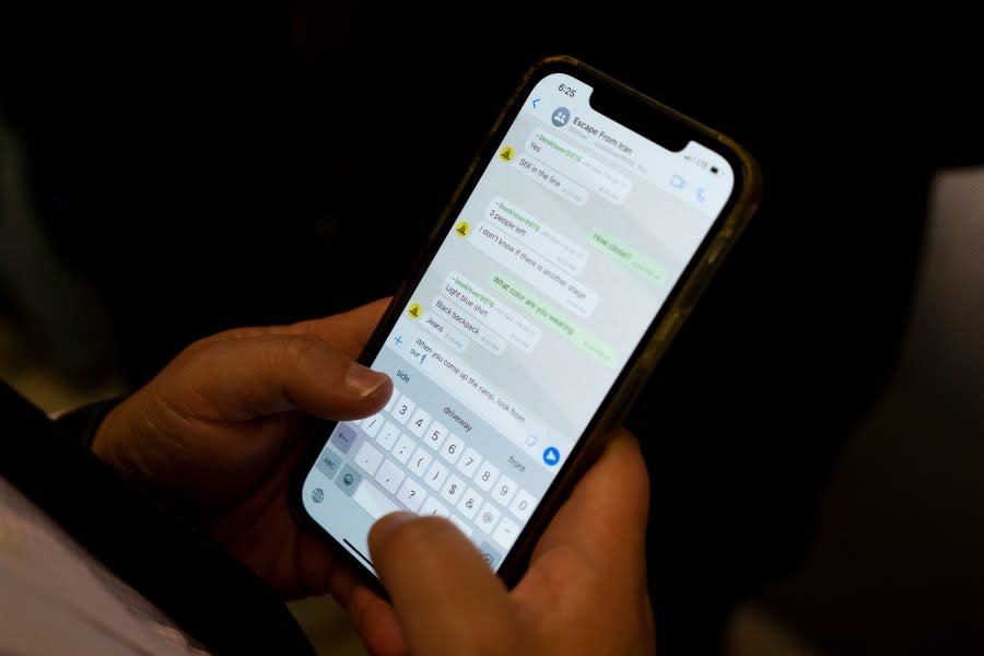 Jonathan Franks, a consultant in the U.S. for families of American hostages and detainees, exchanges text messages with Michael White’s former fellow prisoner and Iranian political activist Mahdi Vatankhah at the Los Angeles International Airport in Los Angeles, Thursday, June 1, 2023. Vatankhah, while in custody and after his release, helped White, a Navy veteran who was jailed in Iran for several years on spying charges, by providing White’s mother with crucial, firsthand accounts about her son’s status in prison and by passing along letters White had written while he was locked up.(AP Photo/Jae C. Hong)