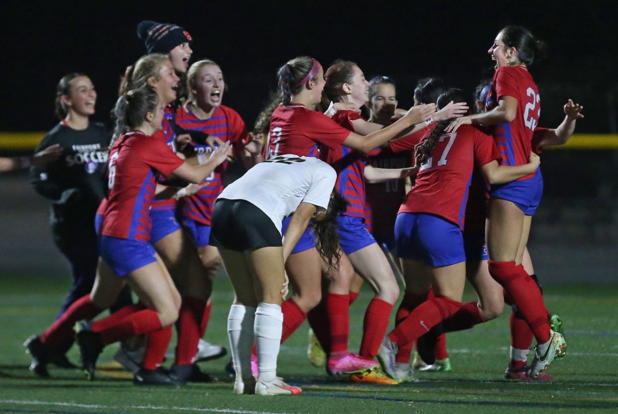 Fairport players mob teammate Andrea Wilson (23) as they celebrate her goal in the second overtime giving the Red Raiders the win over Rush-Henrietta 1-0 in their Section V Class AAA championship final Thursday, Oct. 26, 2023 at Webster Schroeder High School.