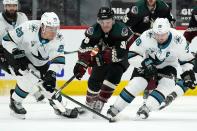 San Jose Sharks right wing Timo Meier, left, controls the puck as Arizona Coyotes right wing Christian Fischer, center, and Sharks center Logan Couture, right, arrive late during the third period of an NHL hockey game Saturday, Jan. 16, 2021, in Glendale, Ariz. The Coyotes defeated the Sharks 5-3. (AP Photo/Ross D. Franklin)