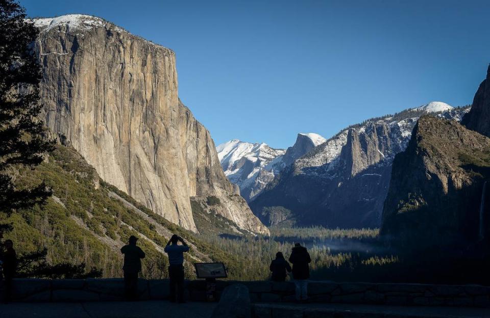 A few park visitors stop to see the El Capitan, left, and Half Dome from Tunnel View in Yosemite National Park after snow dusted the area on Monday, Dec. 9, 2019.