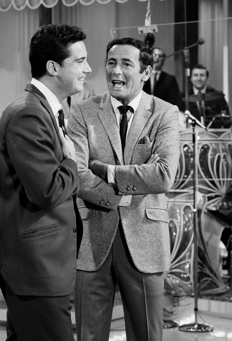 FILE - In this Sept. 15, 1967 file photo, Regis Philbin, of "The Joey Bishop Show" goes over the upcoming routines with Joey Bishop, right, on the set of the ABC-TV studio inLos Angeles. Philbin, the genial host who shared his life with television viewers over morning coffee for decades and helped himself and some fans strike it rich with the game show “Who Wants to Be a Millionaire,” has died on Friday, July 24, 2020. (AP Photo, file)