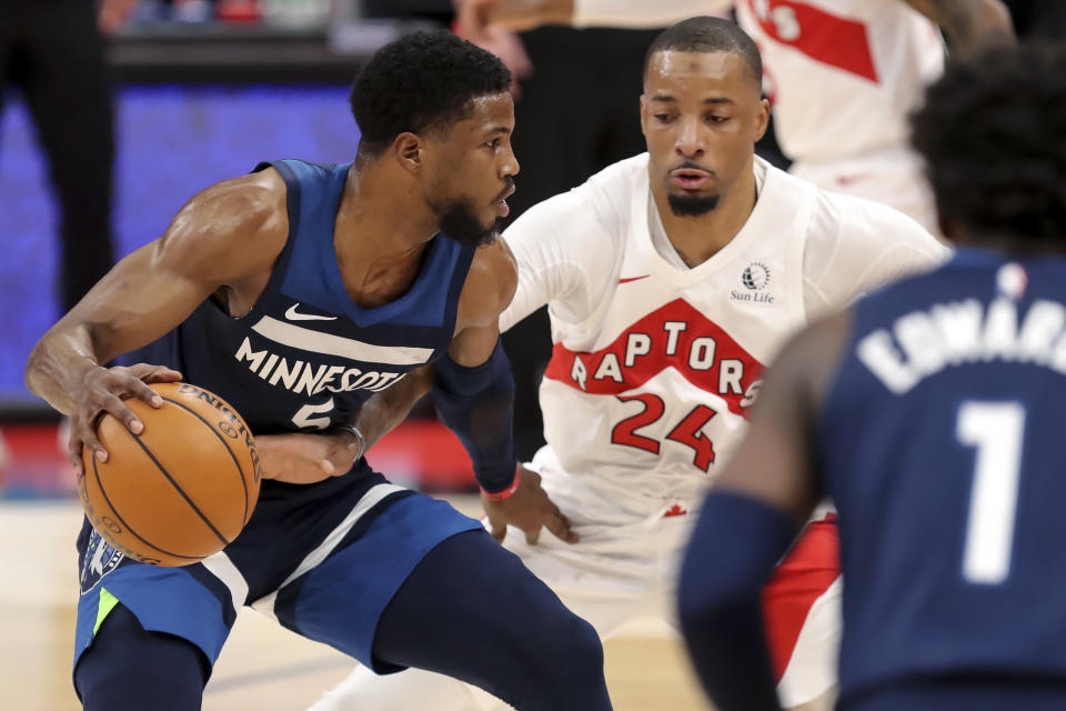 Minnesota Timberwolves' Malik Beasley, left, is defended by Toronto Raptors' Norman Powell during the first half of an NBA basketball game Sunday, Feb. 14, 2021, in Tampa, Fla. (AP Photo/Mike Carlson)