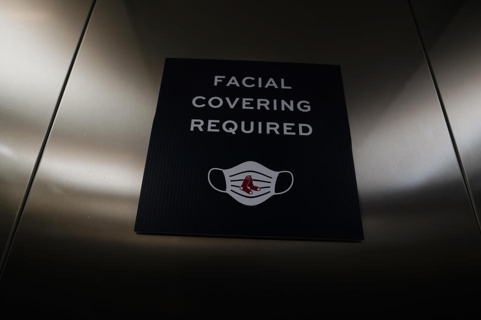 A sign showing that facial coverings are required is seen in a Boston Red Sox' elevator during a spring training baseball game against the Atlanta Braves on Monday, March 1, 2021, in Fort Myers, Fla. (AP Photo/Brynn Anderson)