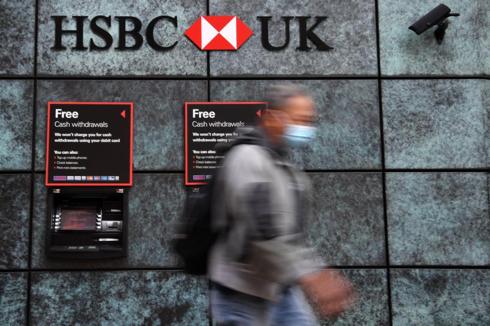 A pedestrian wearing a face mask or covering due to the COVID-19 pandemic, walks past a branch of a HSBC bank in central London on August 3, 2020. - HSBC on Monday revealed a 69-percent slump in net profits, joining a number of major bank whose earnings have been slammed by coronavirus fallout. HSBC announced "reported profit after tax" of $3.1 billion (2.6 billion euros) compared with almost $10 the first six months of 2019, with spiralling China-US tensions also hurting the Asia-focused lender. (Photo by DANIEL LEAL-OLIVAS / AFP) (Photo by DANIEL LEAL-OLIVAS/AFP via Getty Images)