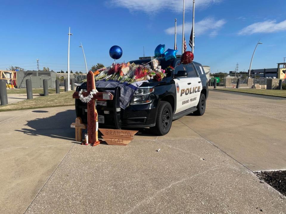 People have flocked to the Grand Prairie Police Department to lay flowers, cards, flags and other things on a patrol vehicle in remembrance of Officer Brandon Tsai.