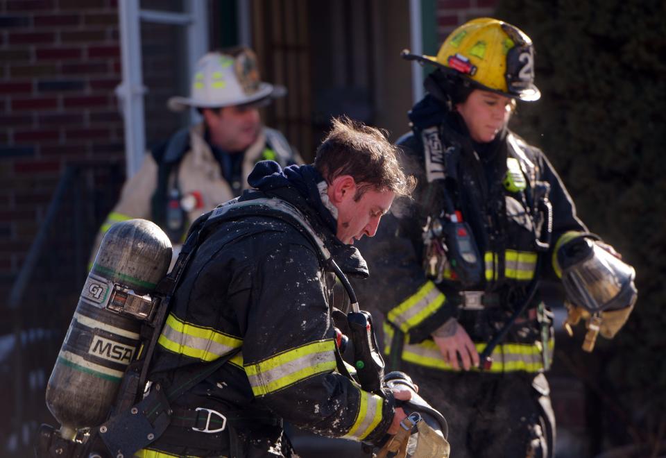 Worcester firefighters walk out of 13 Merriwether Road shortly after it went to a second alarm Sunday.