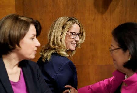 Christine Blasey Ford is greeted by Sen. Mazie Hirono (D-HI) and Sen. Amy Klobuchar (D-MN) (L) during a break in her testimony before the Senate Judiciary Committee on Capitol Hill in Washington, DC, U.S., September 27, 2018. Andrew Harnik/Pool via REUTERS