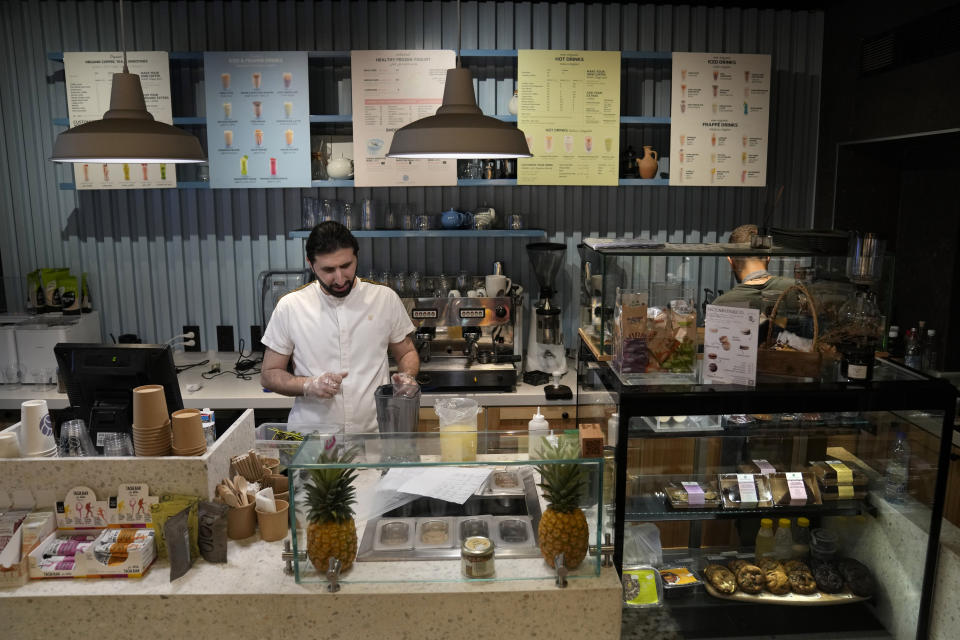 Abbas Bazzi prepares drinks at Le Marché Bio, the organic cafe and grocery store he co-owns, in Beirut, Lebanon, Tuesday, May 30, 2023. Bazzi, who grew up in a secular family but was interested in Islam from an early age, hopes to travel to the Muslim holy city of Mecca, Saudi Arabia, for his fourth Hajj pilgrimage this month. (AP Photo/Hussein Malla)