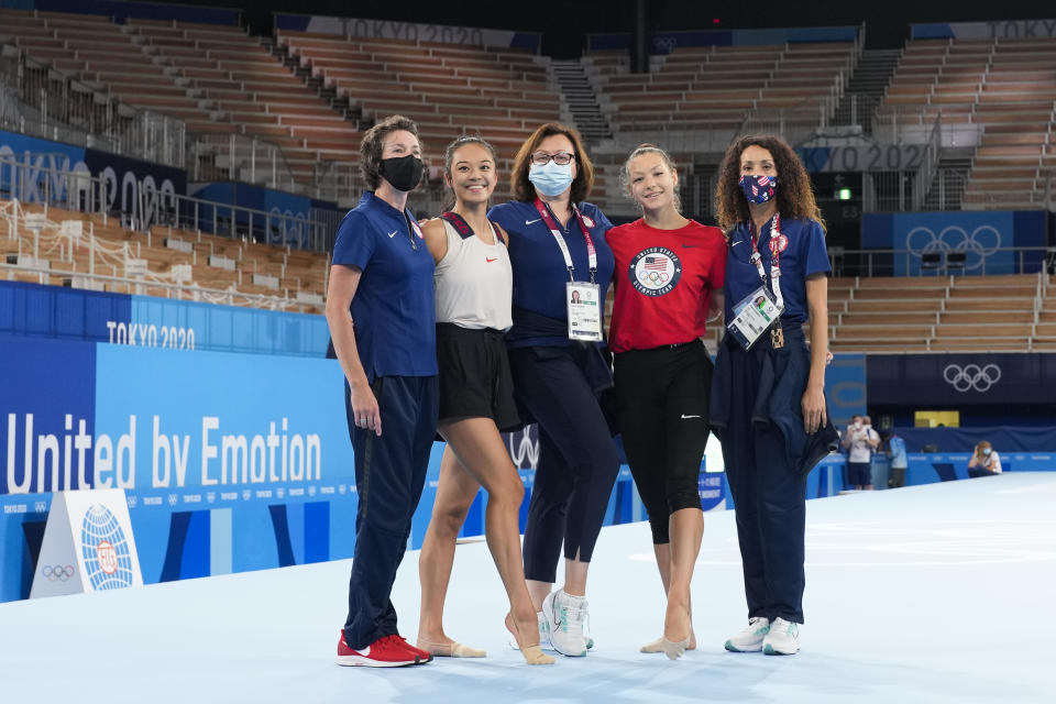 Laura Zeng, second from left, and Evita Griskenas, second from right, from the United States pose with their coaches after an individual rhythmic gymnastics training session at the 2020 Summer Olympics, Thursday, Aug. 5, 2021, in Tokyo, Japan. (AP Photo/Markus Schreiber)